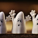 Three friendly looking ghosts wave their arms